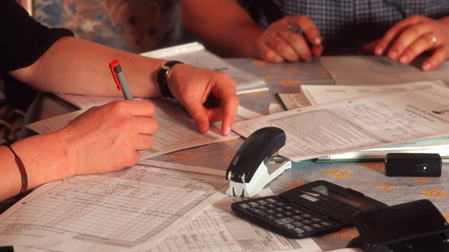 Hände auf dem Tisch beim Ausfüllen einiger Formulare