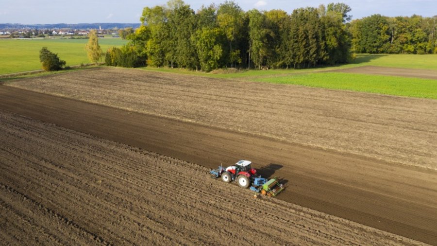 Traktor fährt auf Feld