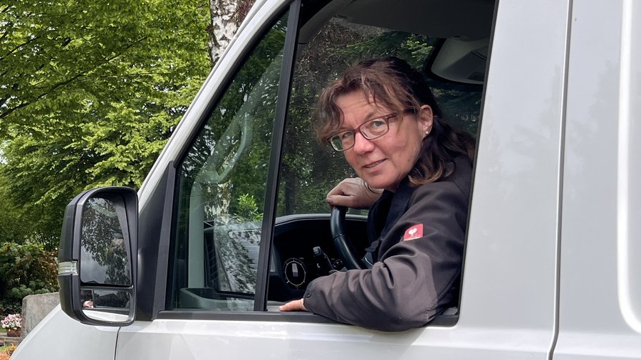 Iris Wolf schaut aus dem Fahrerfenster ihres Transporters und lacht.