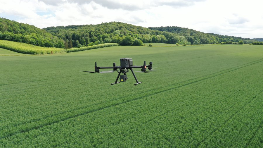 Eine Drohne fliegt über einen Acker.