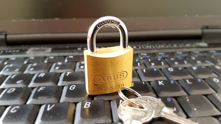 Auf der Tastatur liegt ein goldenes Schloss mit zwei Schlüsseln.