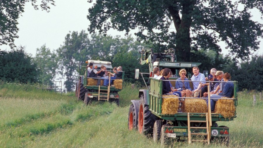 Mehrere Menschen sitzen auf einem Anhänger der von einer Traktor gezogen wird. Bild: BLE