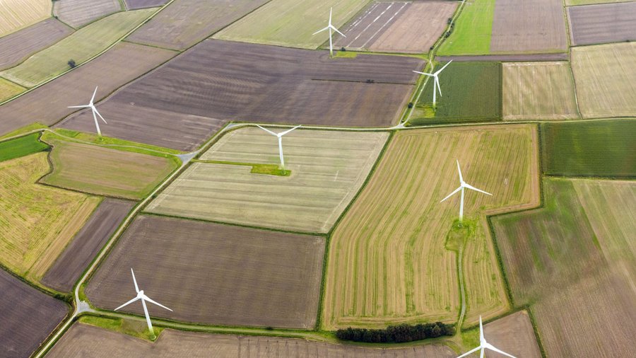 Luftaufnahme von Äckern mit Windrädern. Bild: miboffb/stock.adobe.com