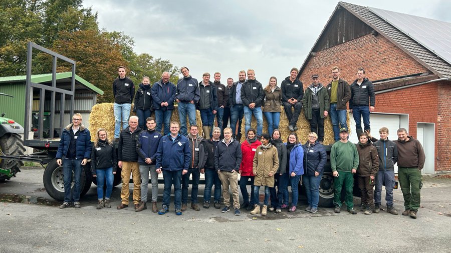 Eine Gruppe von Menschen steht auf einem Hof.