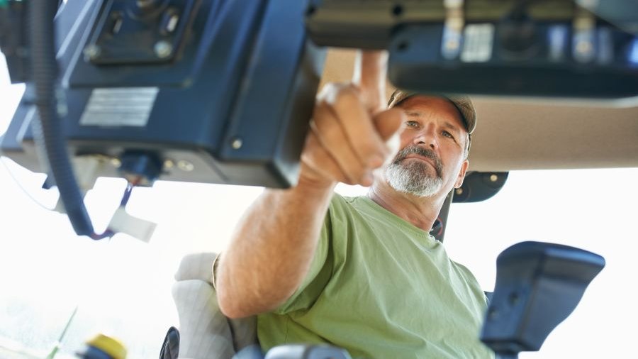 Mann sitzt in einem Traktor. Bild: jeffbergen/E+/Getty Images Plus via Getty Images