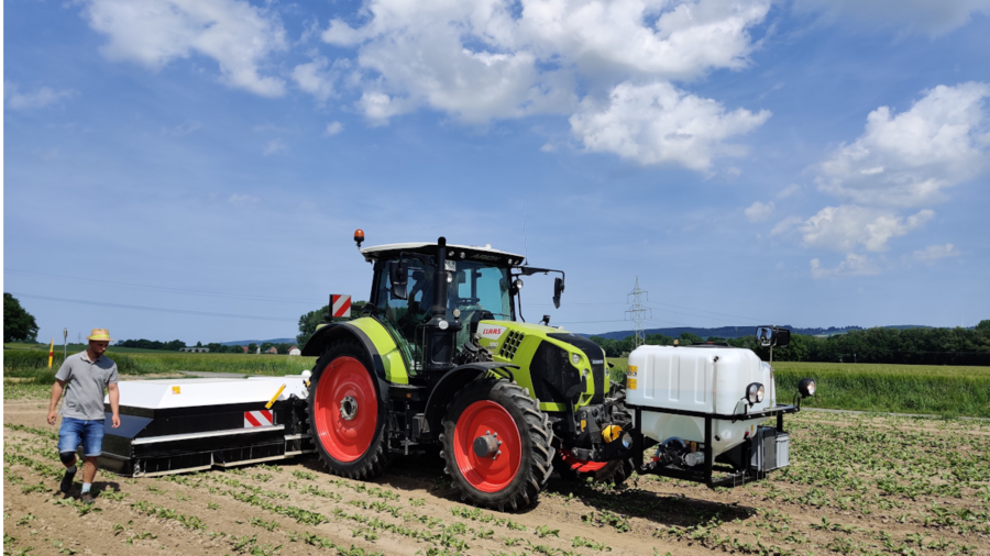 Ein Traktor auf dem Feld zur Behandlung von Unkrautpflanzen.