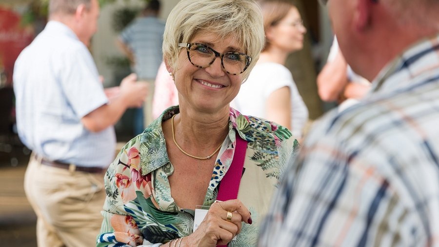 Eva Kähler-Theuerkauf ist im Gespräch mit Personen auf einer Feierlichkeit.