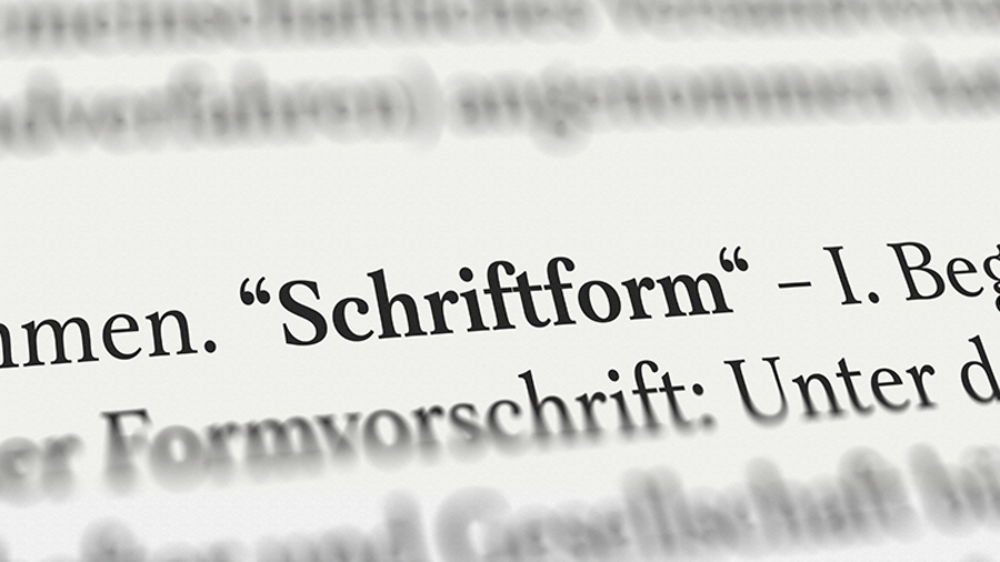 Foto auf lexikalische Buchseite, auf der das Wort Schriftform fettgeschrieben und gut lesbar ist. Alles andere ist unscharf.
