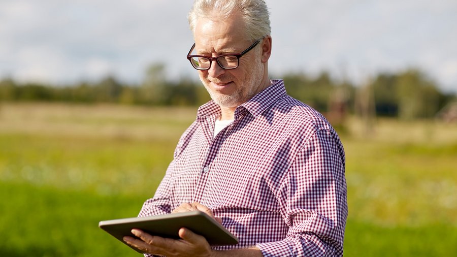 Mann mit Tablet in der Hand im Feld