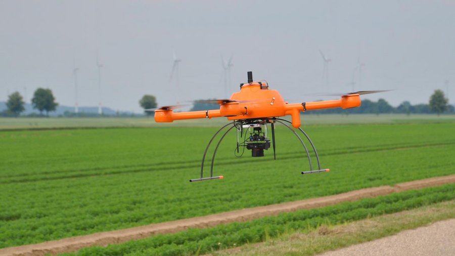 Drohne fliegt über einem Acker