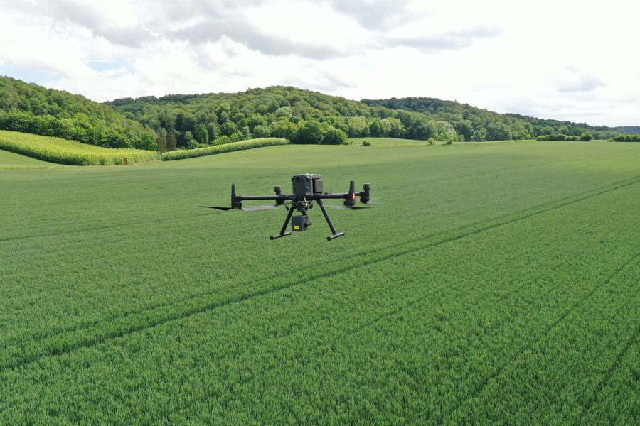 Eine Drohne fliegt über einen Acker.