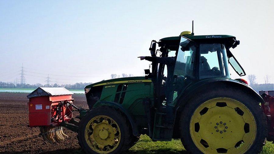 Traktor mit vorne angebautem Kastenstreuer