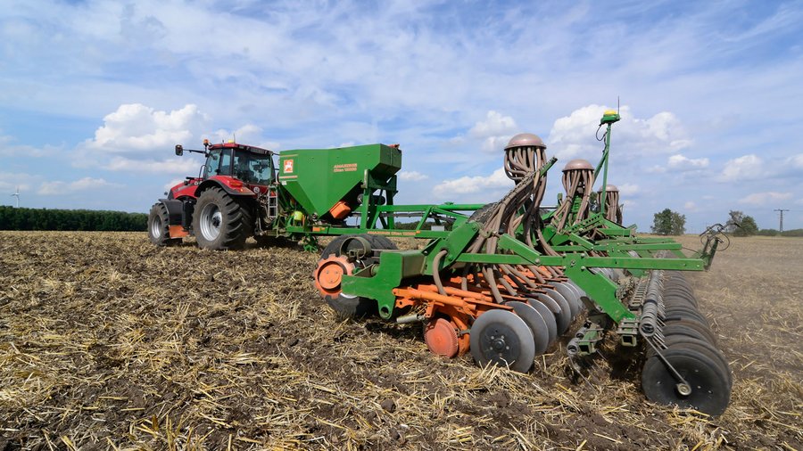 Traktor mit Sämaschine auf Stoppelfeld